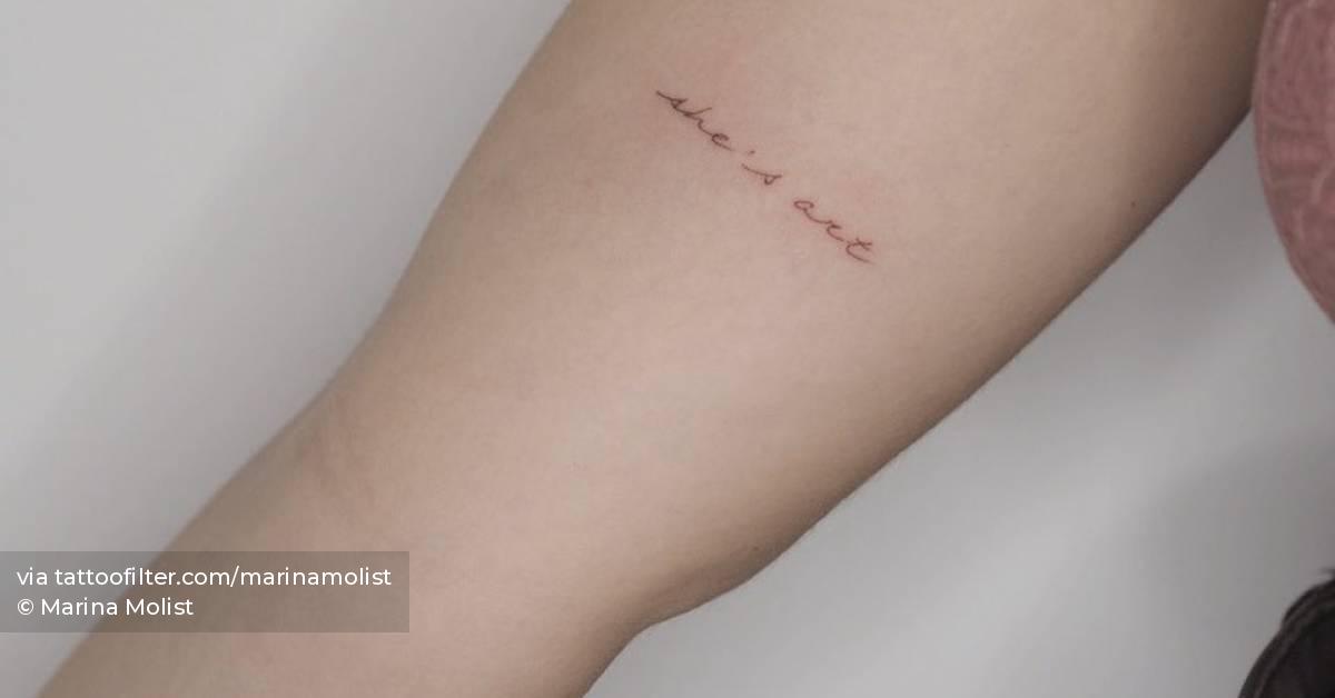 Tattoo written "she’s art" located on the inner arm.