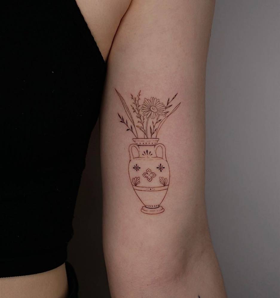 Tattoo of flowers in a vase, done in fine line, located