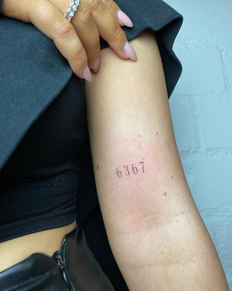 Tattoo of the number "6367" done on the bicep.