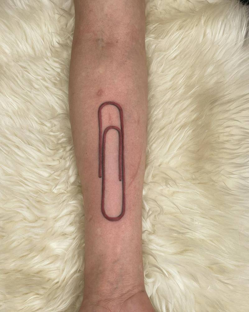 Large paperclip tattooed on the inner forearm.