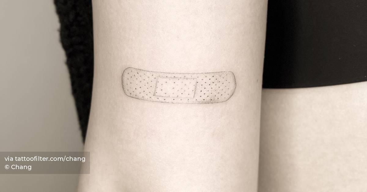 Microrealistic bandage tattoo located on the tricep.