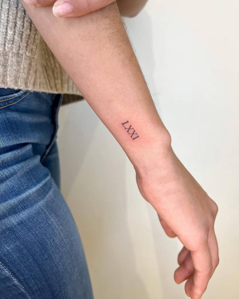 Roman numerals tattoo located on the wrist.