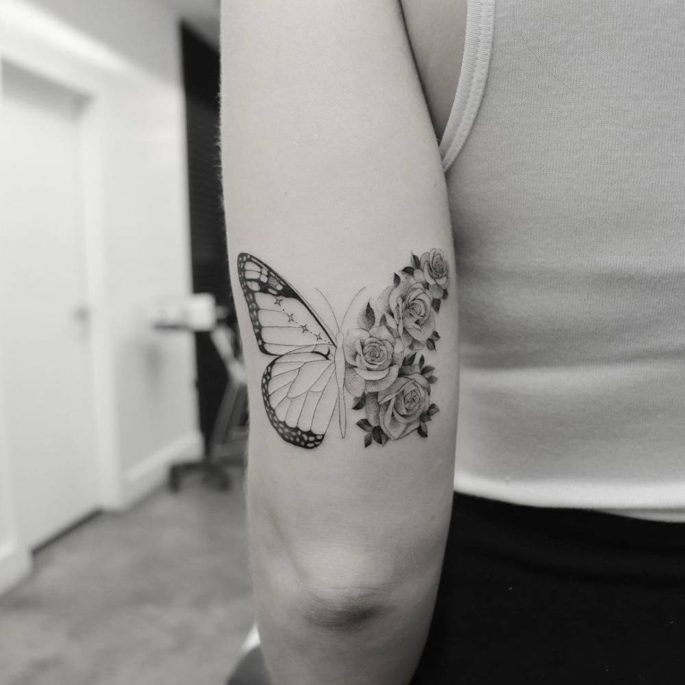 Half butterfly half flowers tattoo on the tricep.