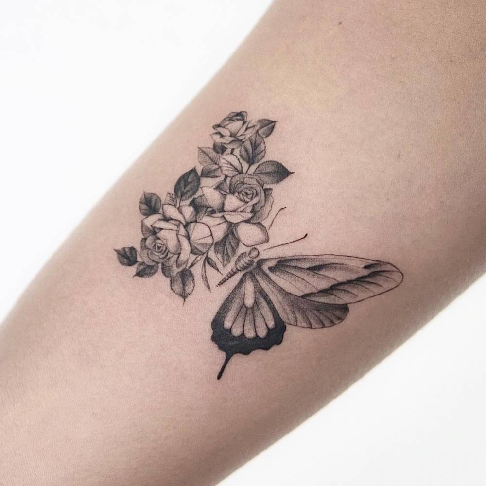 Half butterfly half flowers tattooed on the inner arm.