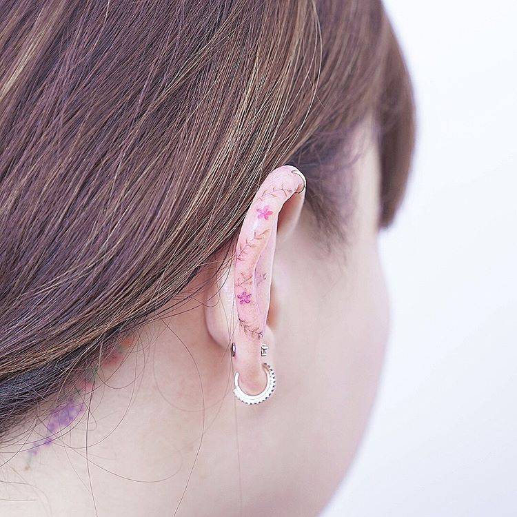 Flower tattoo on the left ear.