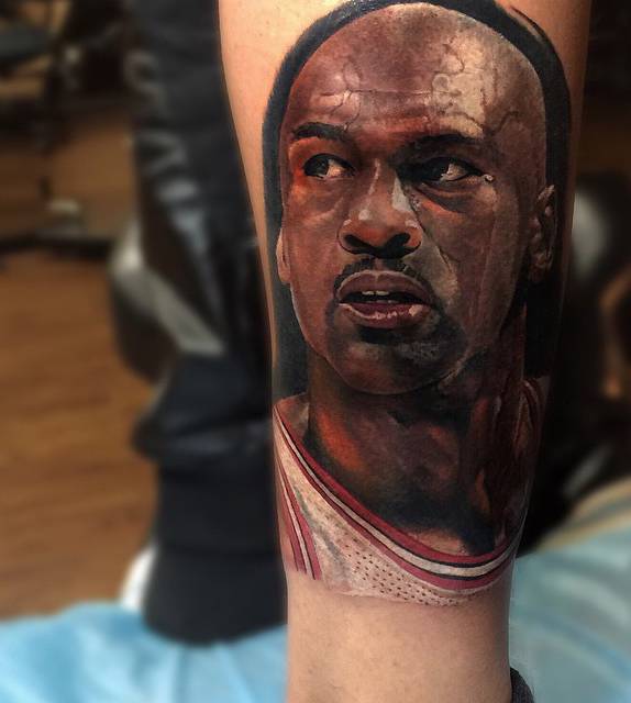 Michael Jordan's realistic portrait tattoo on the leg.