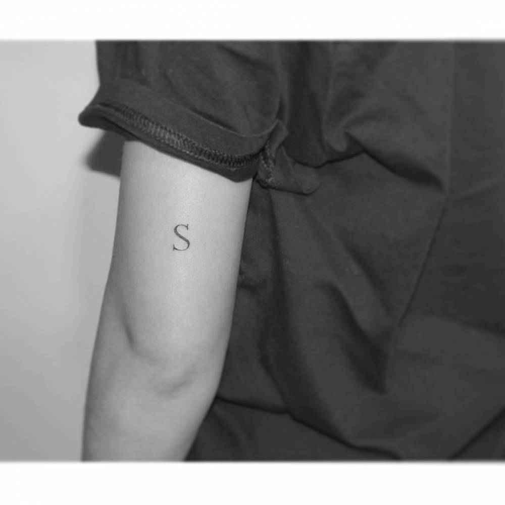 Letter "S" tattoo placed on the tricep.