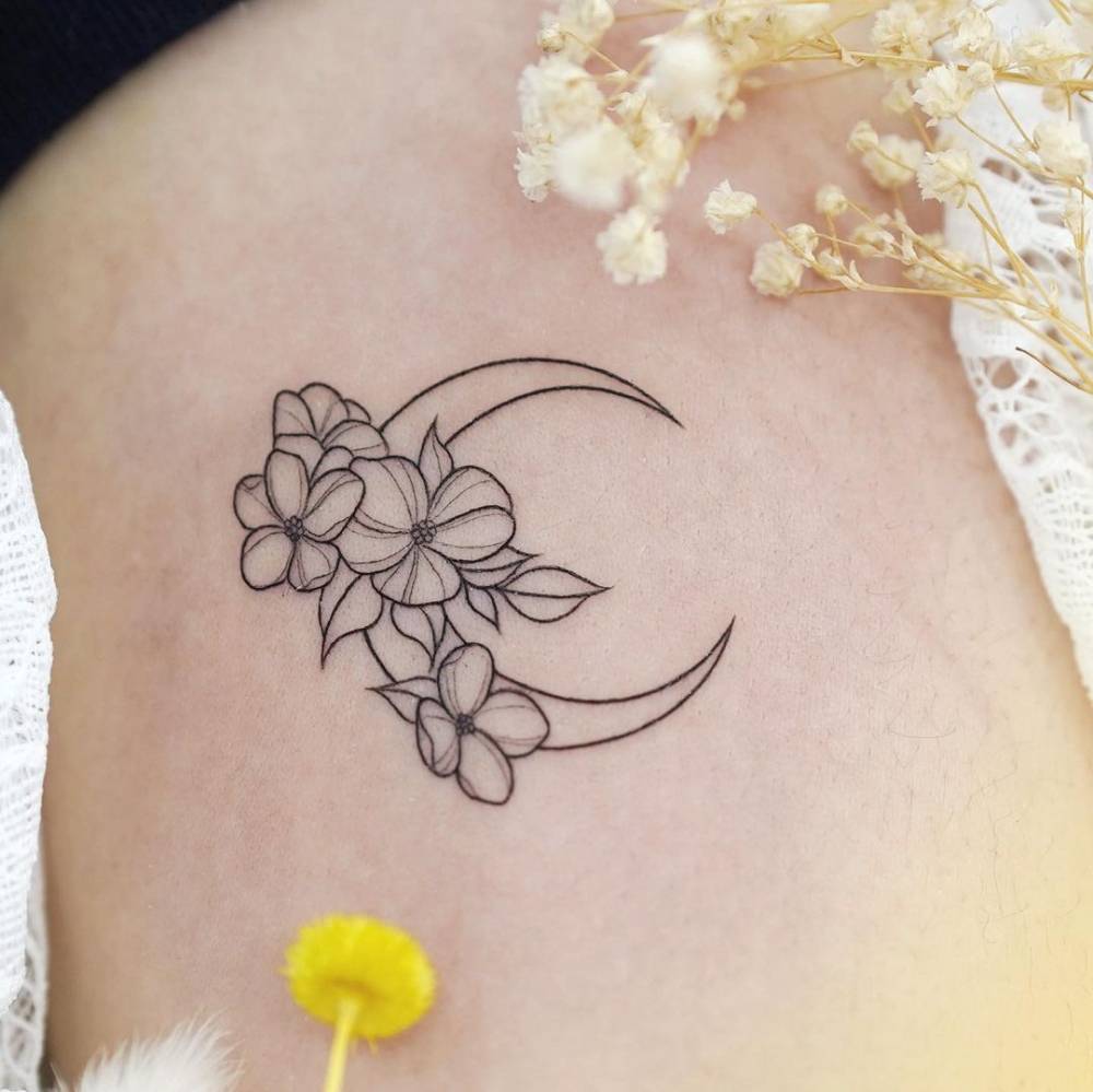 Fine line flower moon tattoo located on the rib.