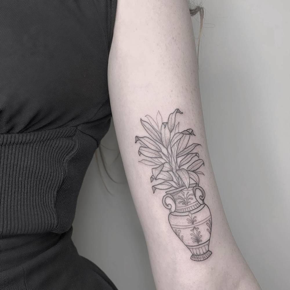 Plant vase tattoo located on the bicep, fine line