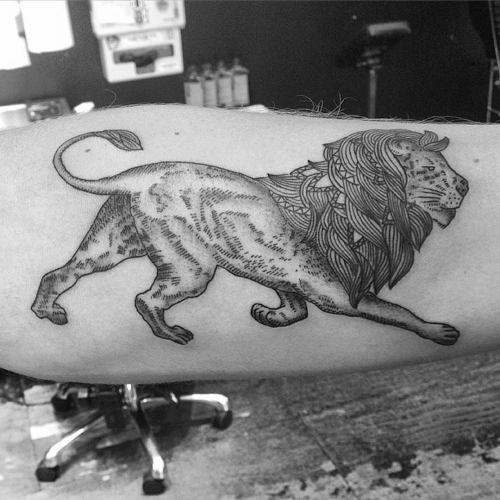 Lion tattoo on the left forearm.