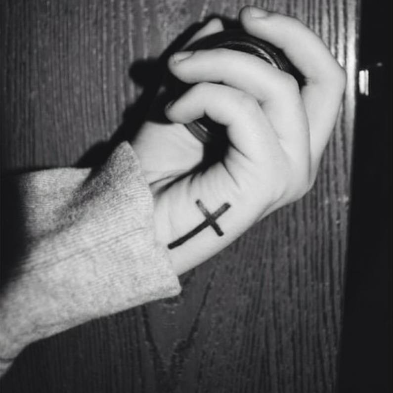 Little hand tattoo of a cross on Aspen Rose.