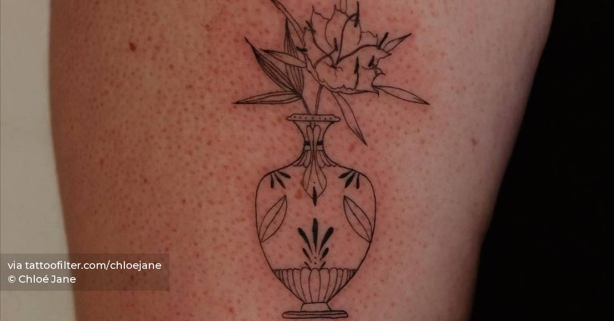 Plant vase tattoo located on the upper arm.