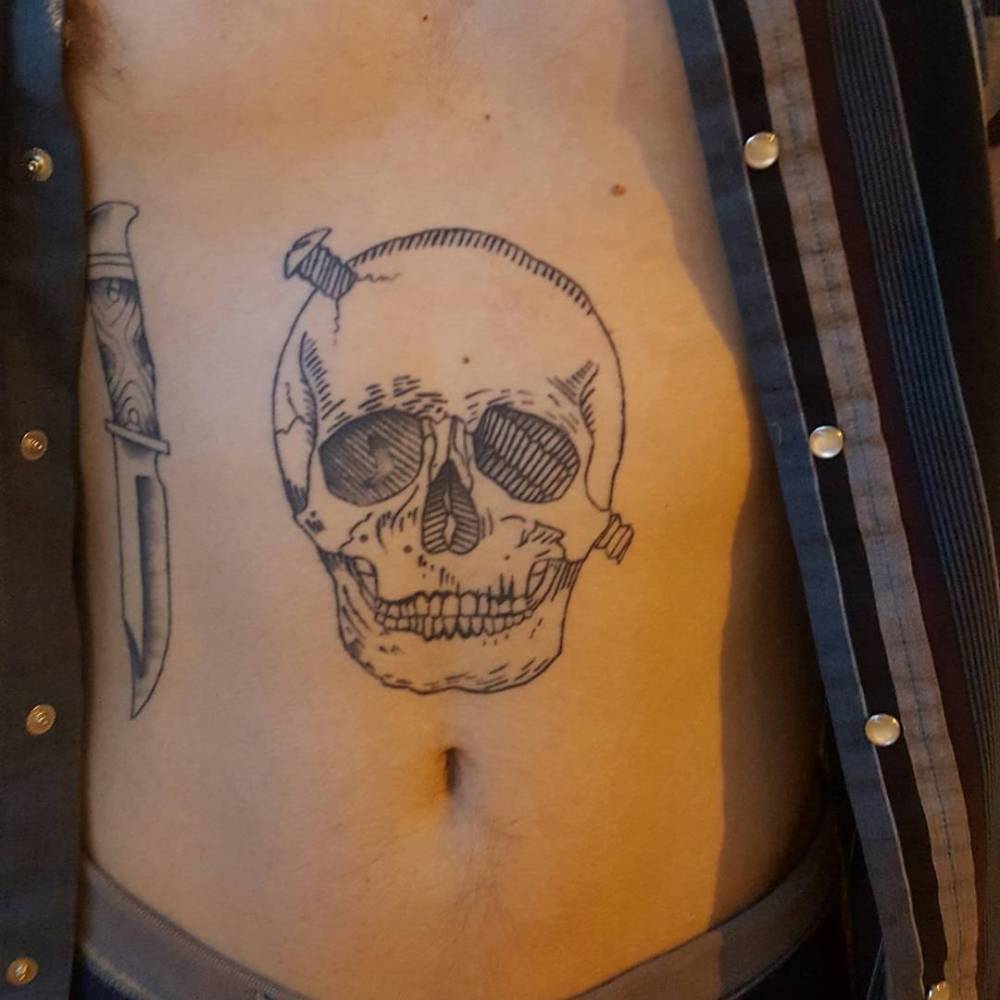 Few months healed engraving style skull tattoo located