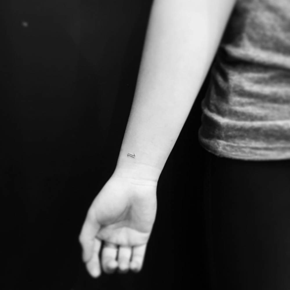 Reversible reaction symbol tattoo located on the wrist.