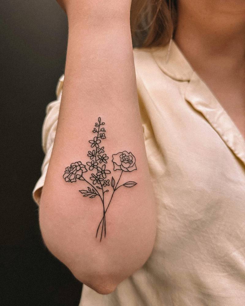 Fine line flower bouquet tattoo located on the forearm.