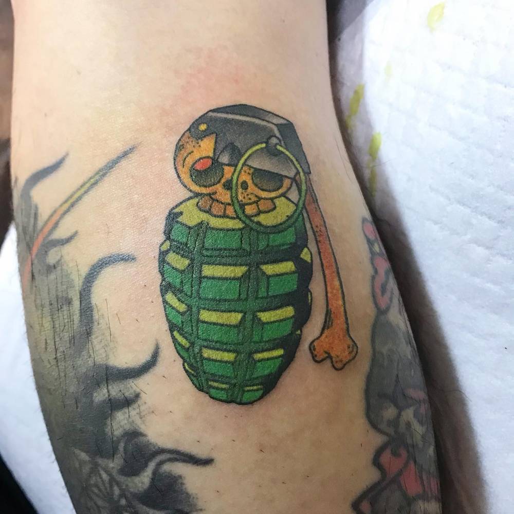 Grenade tattoo located on the inner forearm, cartoon