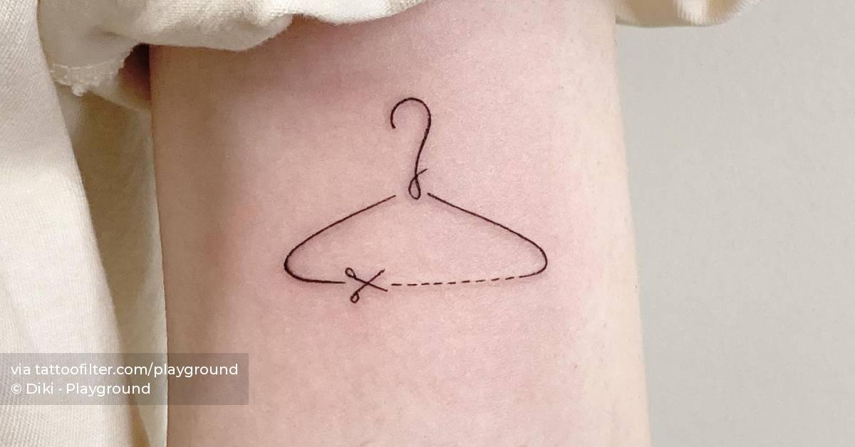 Fine line style clothes hanger tattoo located on the