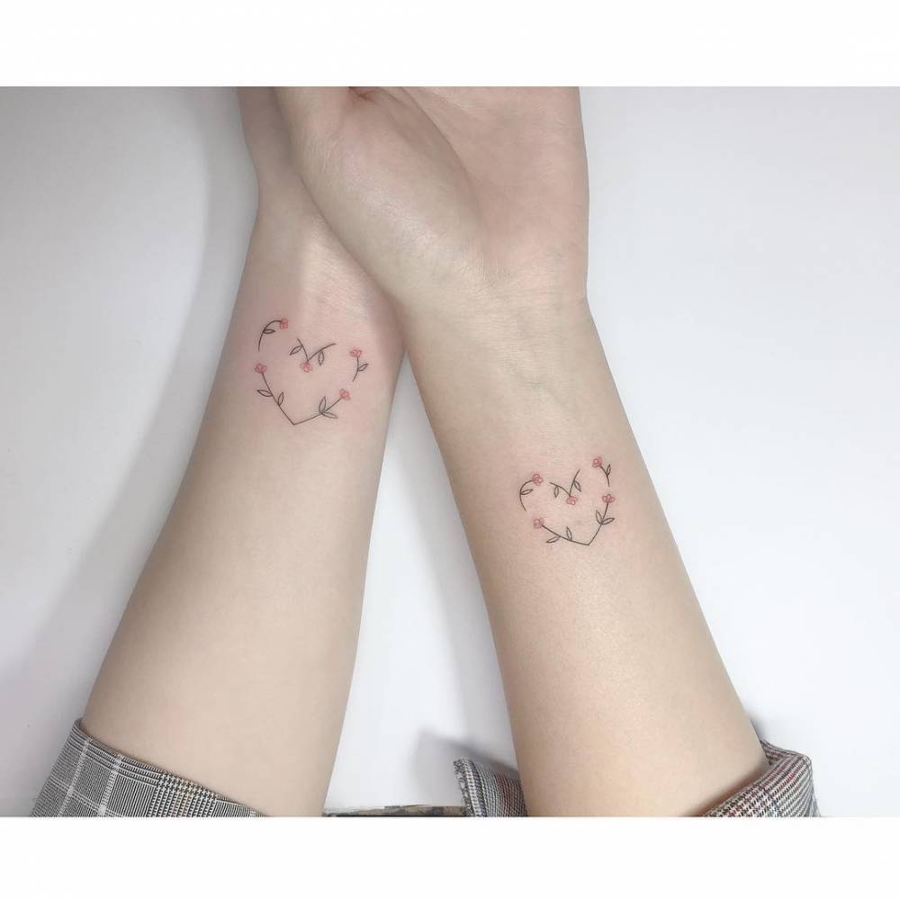 Matching flower heart tattoo for couple.