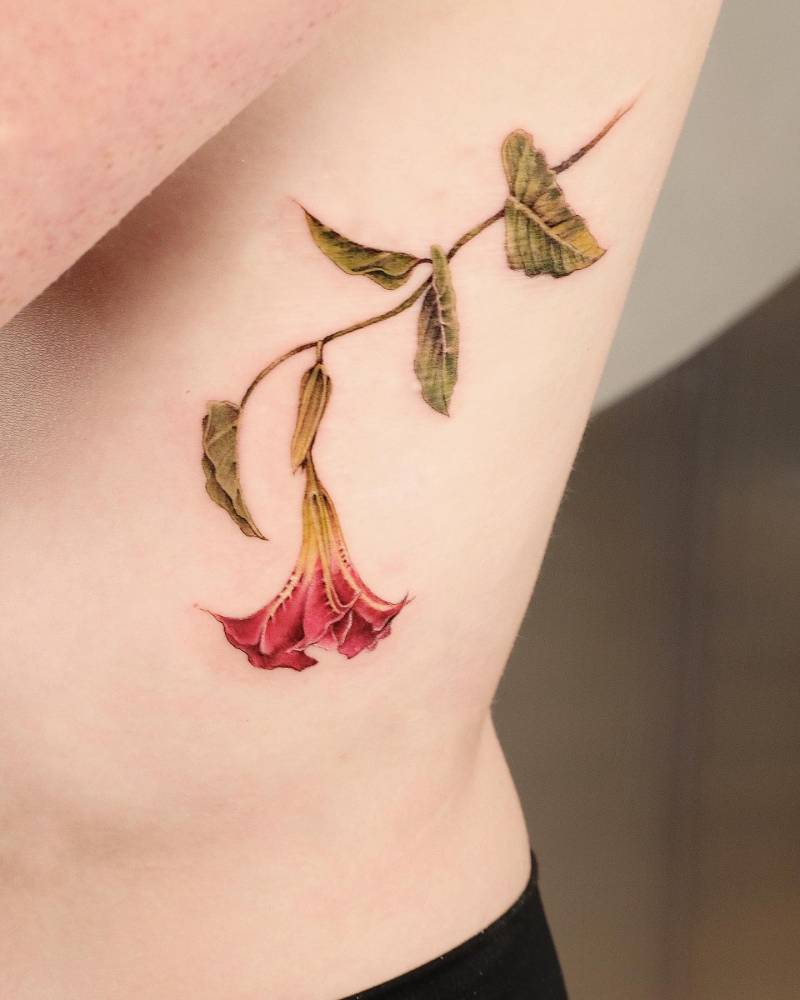Angel’s Trumpet flower tattooed on the rib,