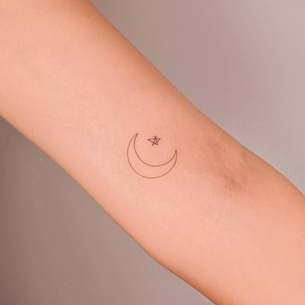 Crescent moon and star tattoo located on the inner arm,