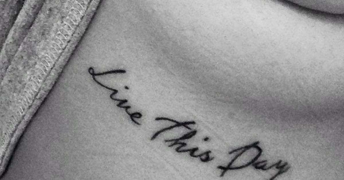 Under the breast tattoo saying “Live This Day” on