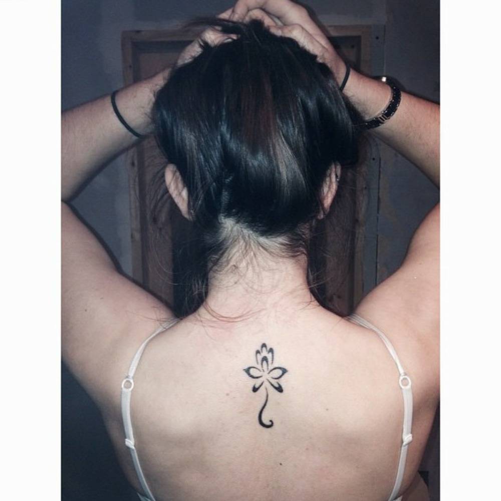 Upper back tattoo of a lotus flower on Shannon.