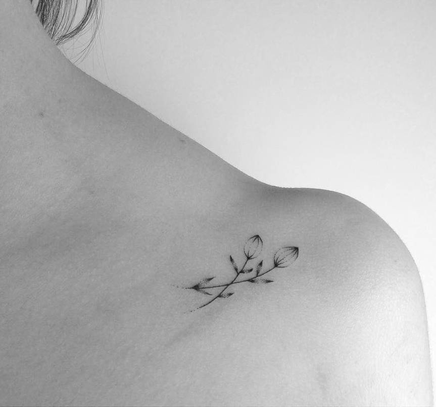 Handpoked small delicate flower tattoo on the left