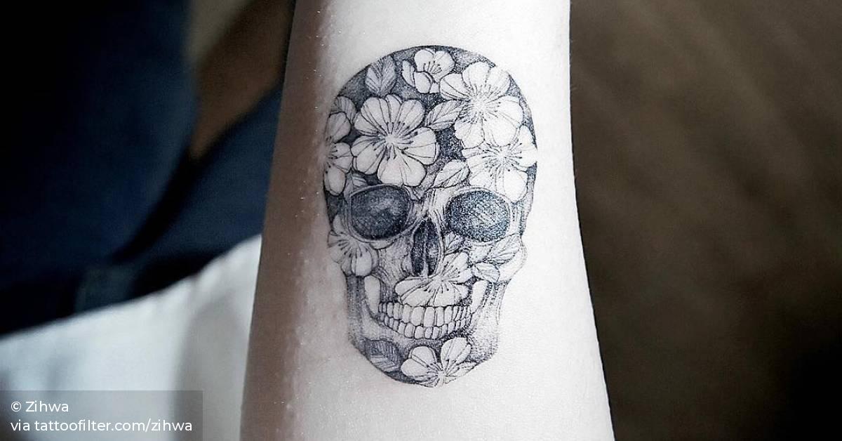 Flower skull tattoo on the right inner arm.