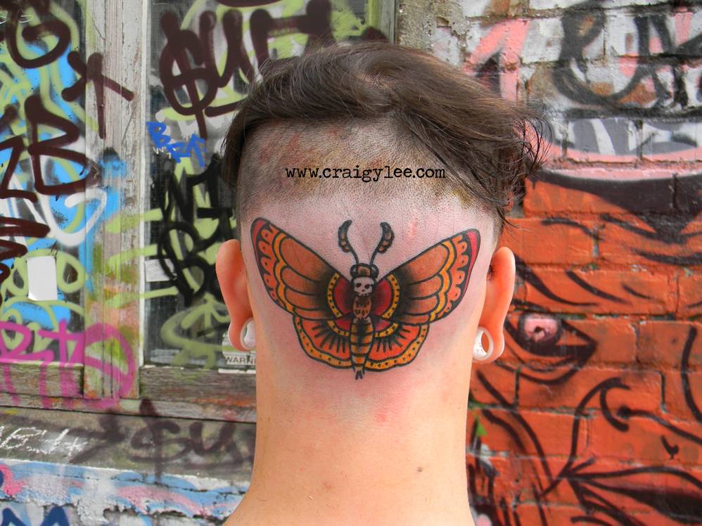 Head tattoo of a butterfly by Craigy Lee.