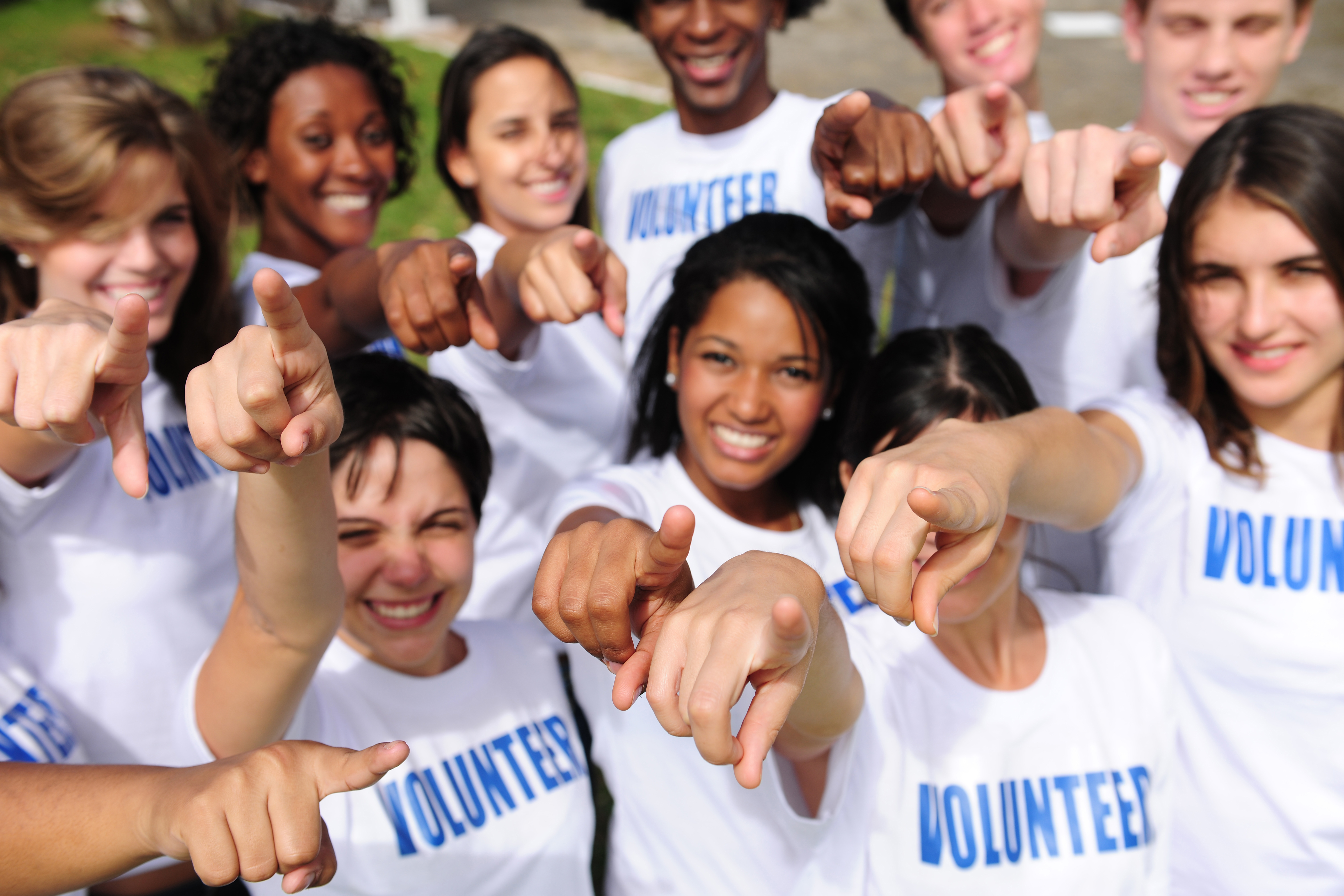 Children’s Foundation of America happy volunteer group pointing towards