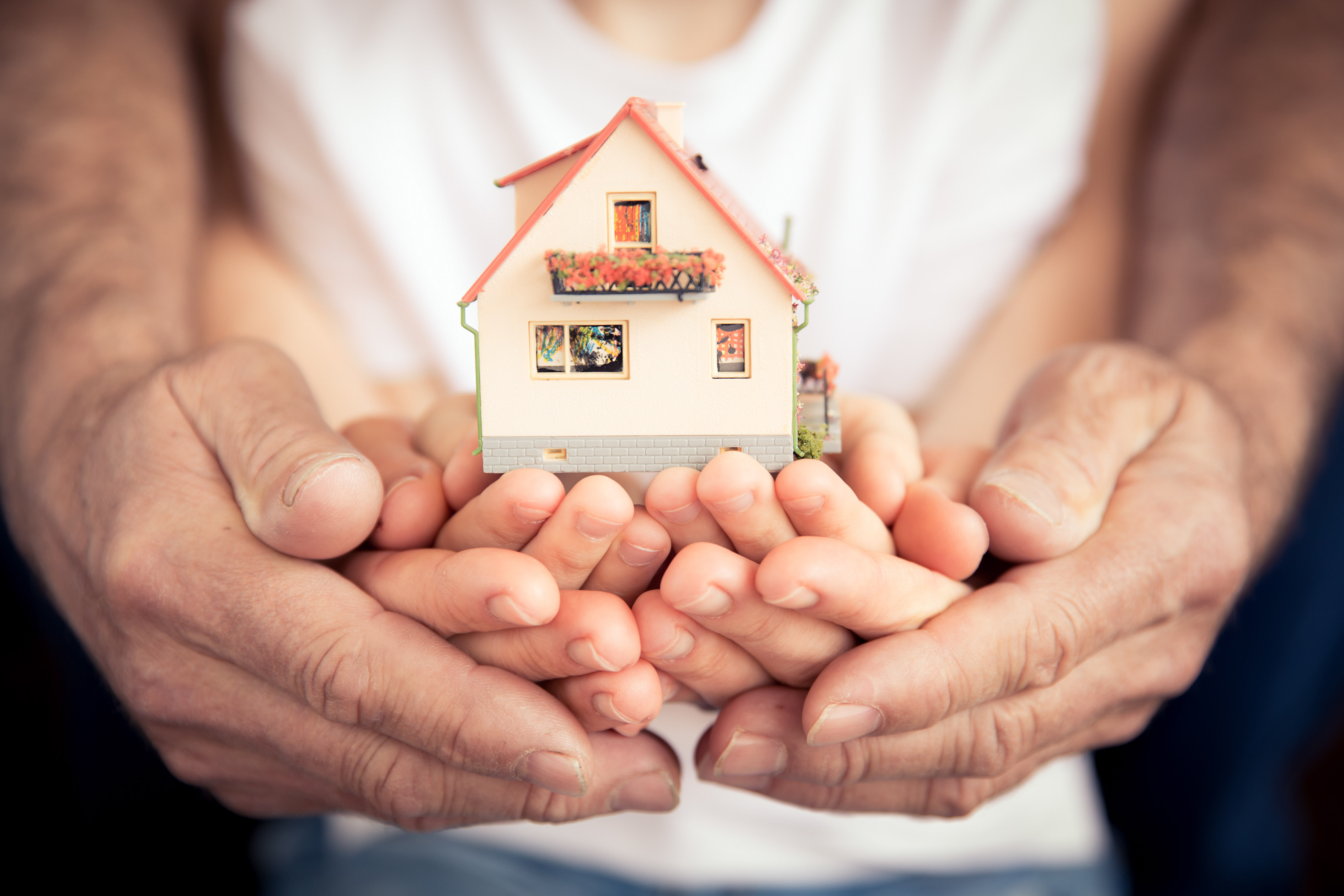 Family holding house in hands CrawKan Telephone Cooperative