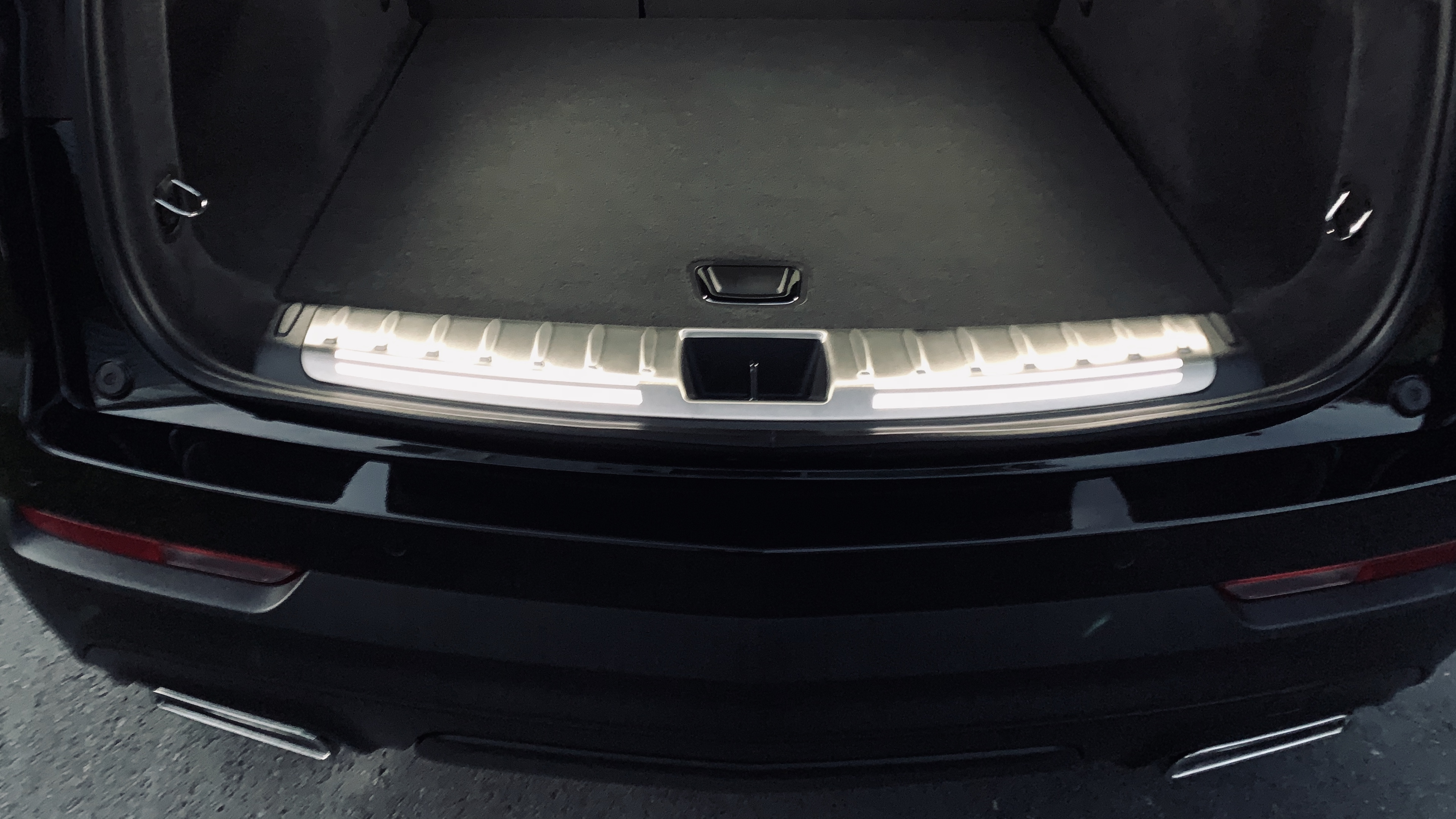 Illuminated cargo sill plate with premium carpet cargo mat Cadillac