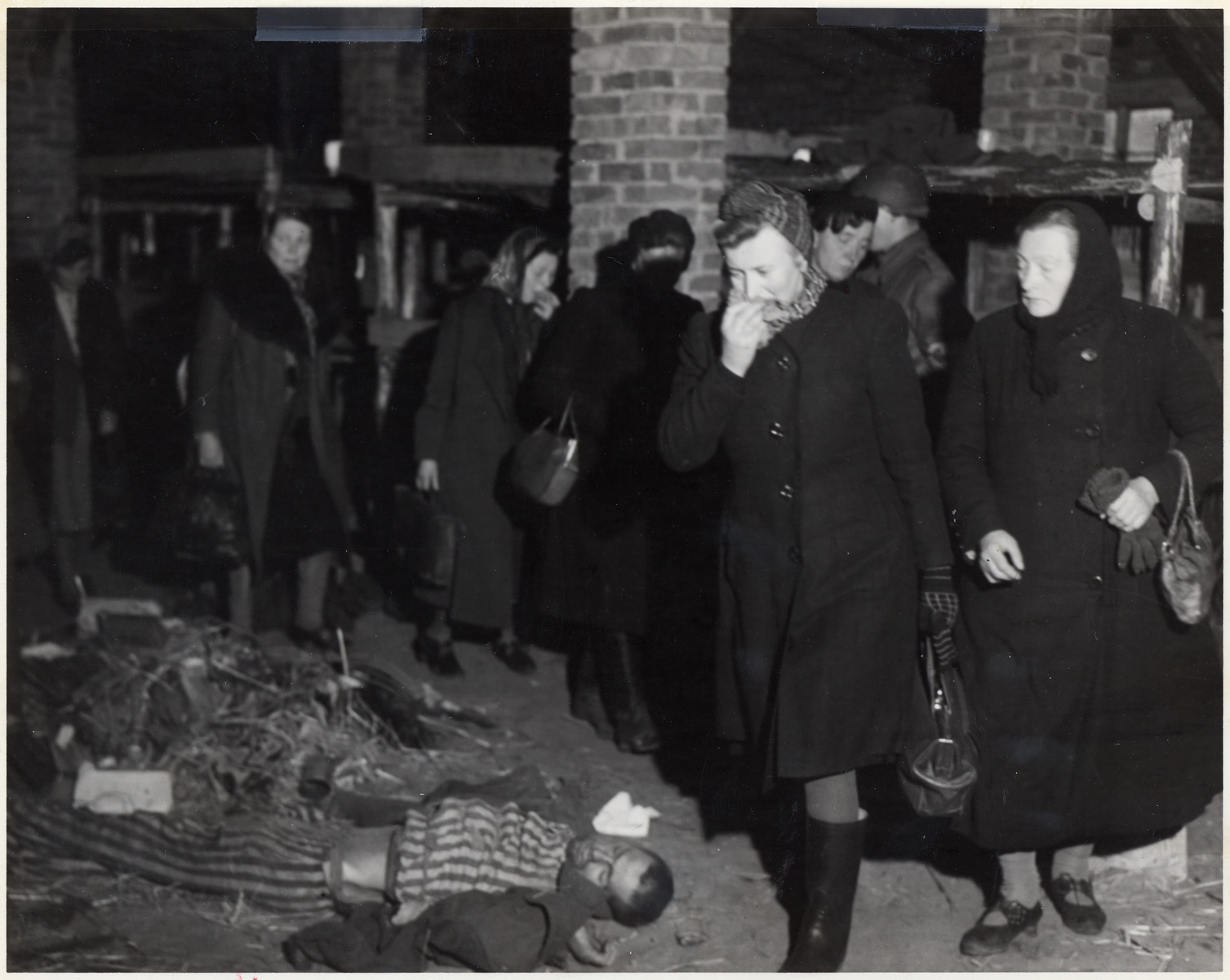 German women are forced to march through a corpse filled barracks of
