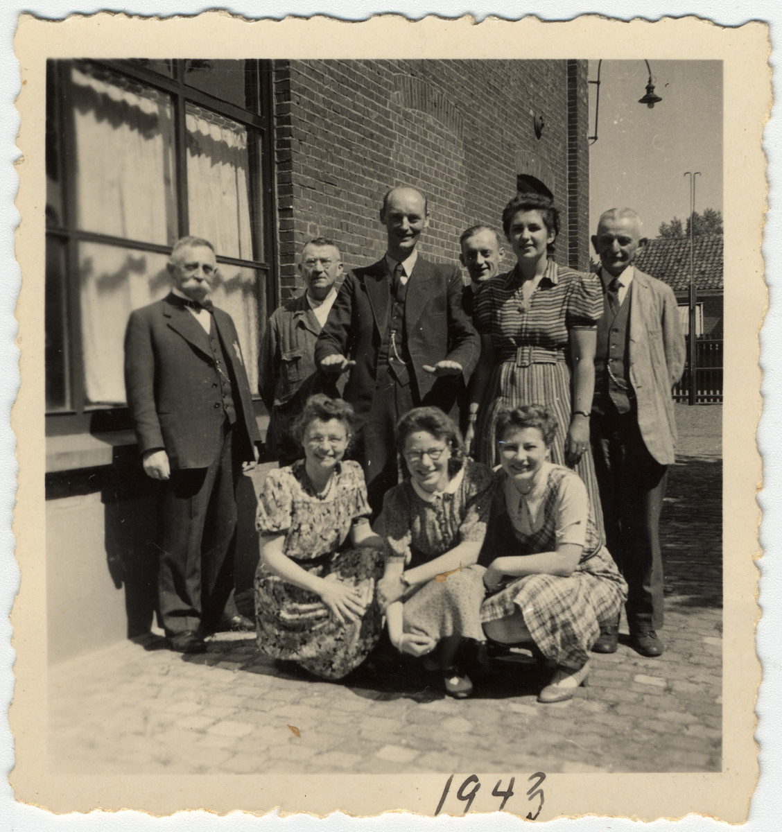 A Jewish businessman poses with the workers in his textile factory "M