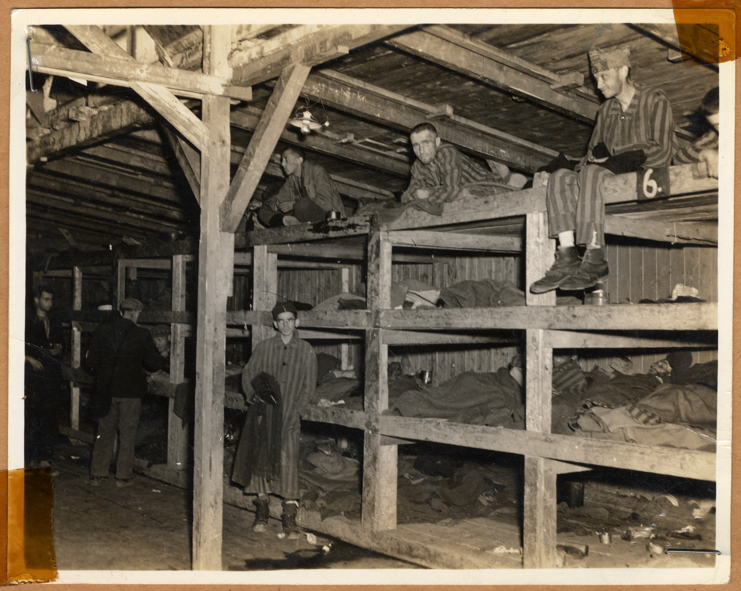 Survivors sit in multitiered bunks in a barracks in the newly