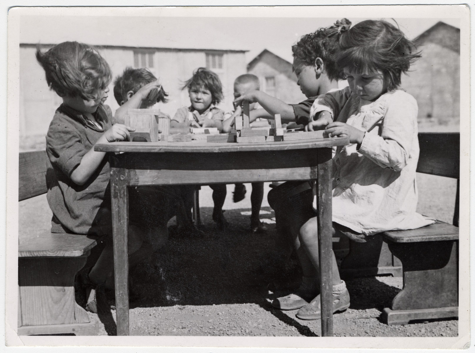 A small group of Spanish children sit at a table in the Rivesaltes