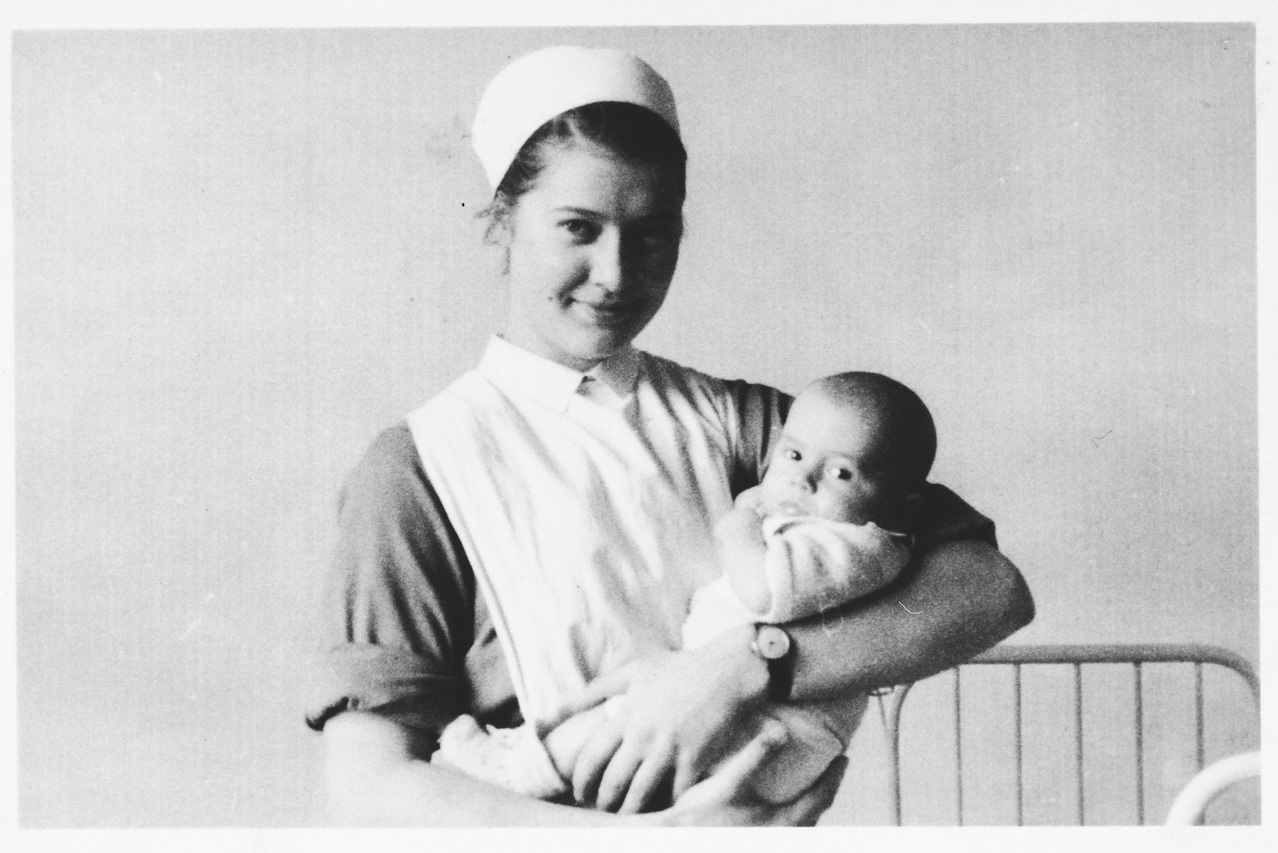 A nurse cradles a Jewish infant who is being sheltered at the Clinique