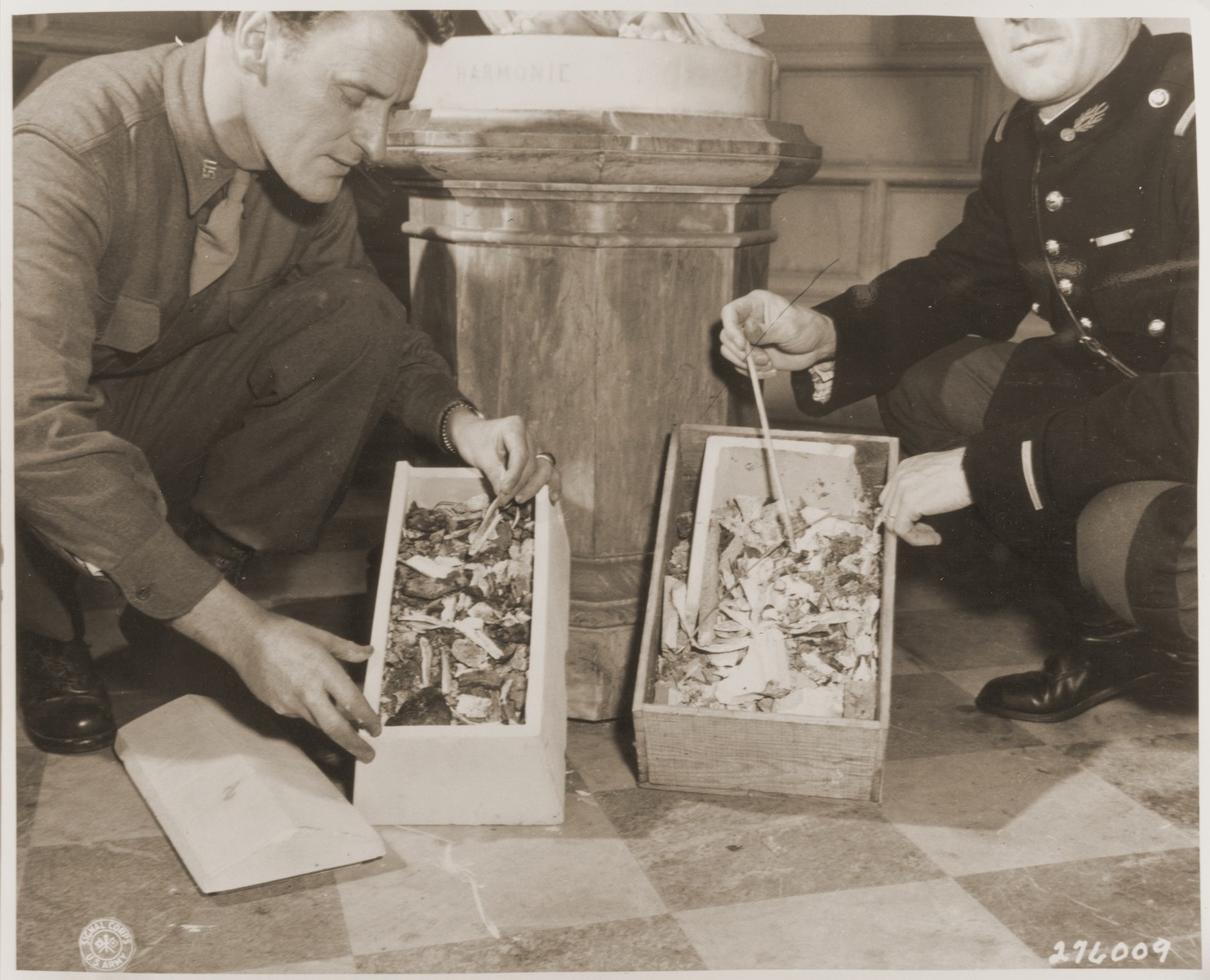 An American and a French soldier examine boxes containing the remains