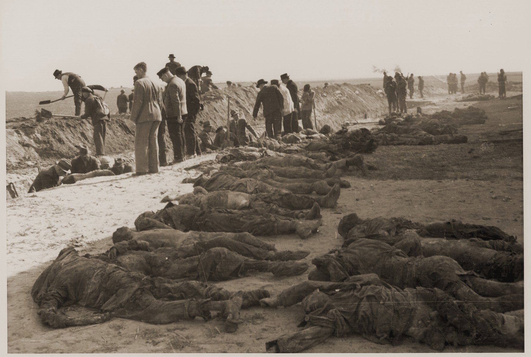 Under the supervision of American soldiers, German civilians exhume a