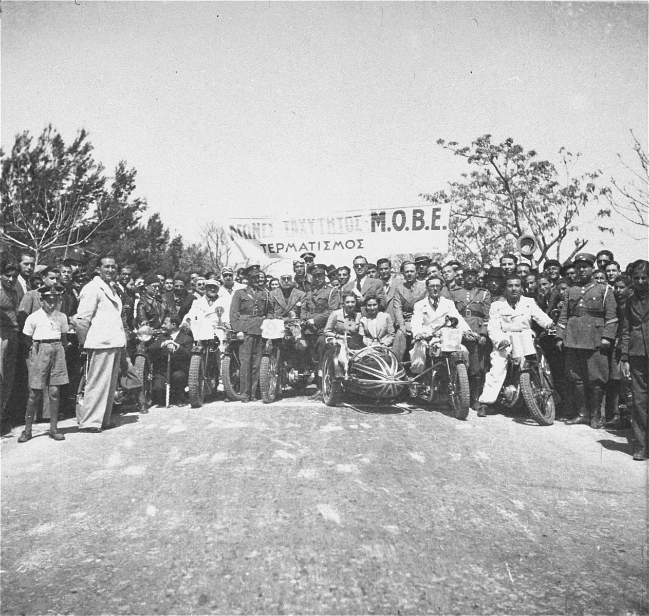 Competitors And Spectators Pose At The Starting Line Of A Motorcycle