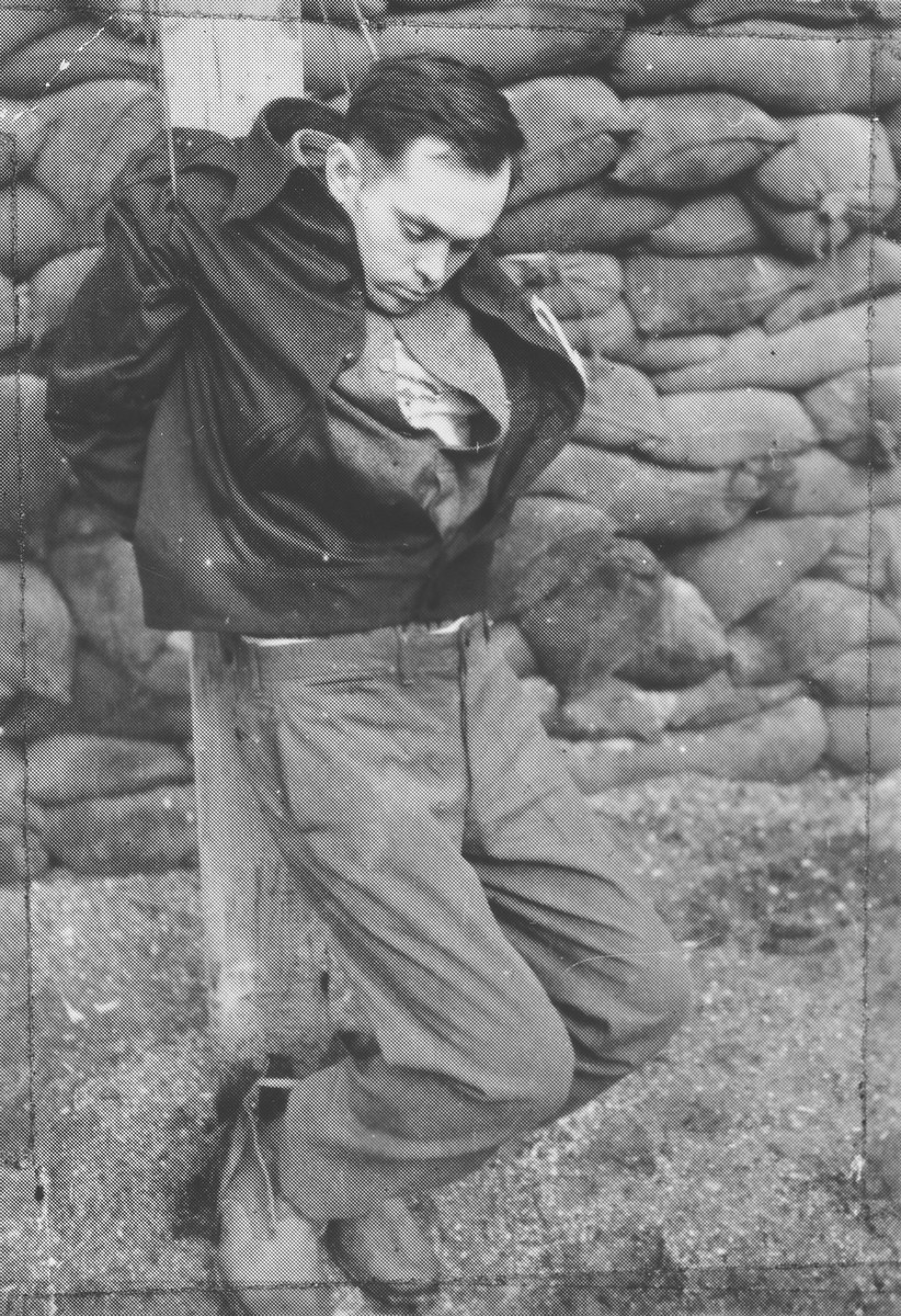 The body of Peter Chemy hangs lifeless on a post after his execution by