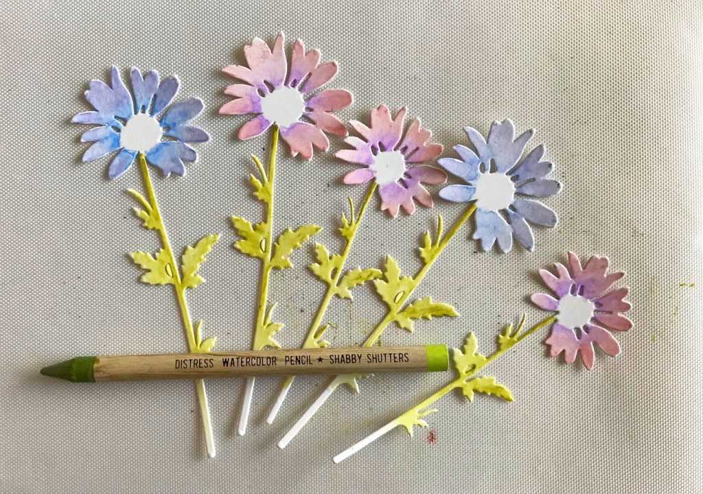 Photo showing the daisies from Tim Holtz and the Shabby Shutters Distress Watercolor Pencil used to color the stems and leaves for today’s Spring Flower Bouquet Card With Free SVG File post.