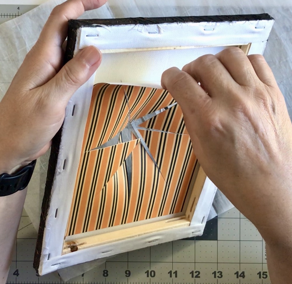 Photo showing the scrapbook paper pulling away from the back of the canvas in today's project. 