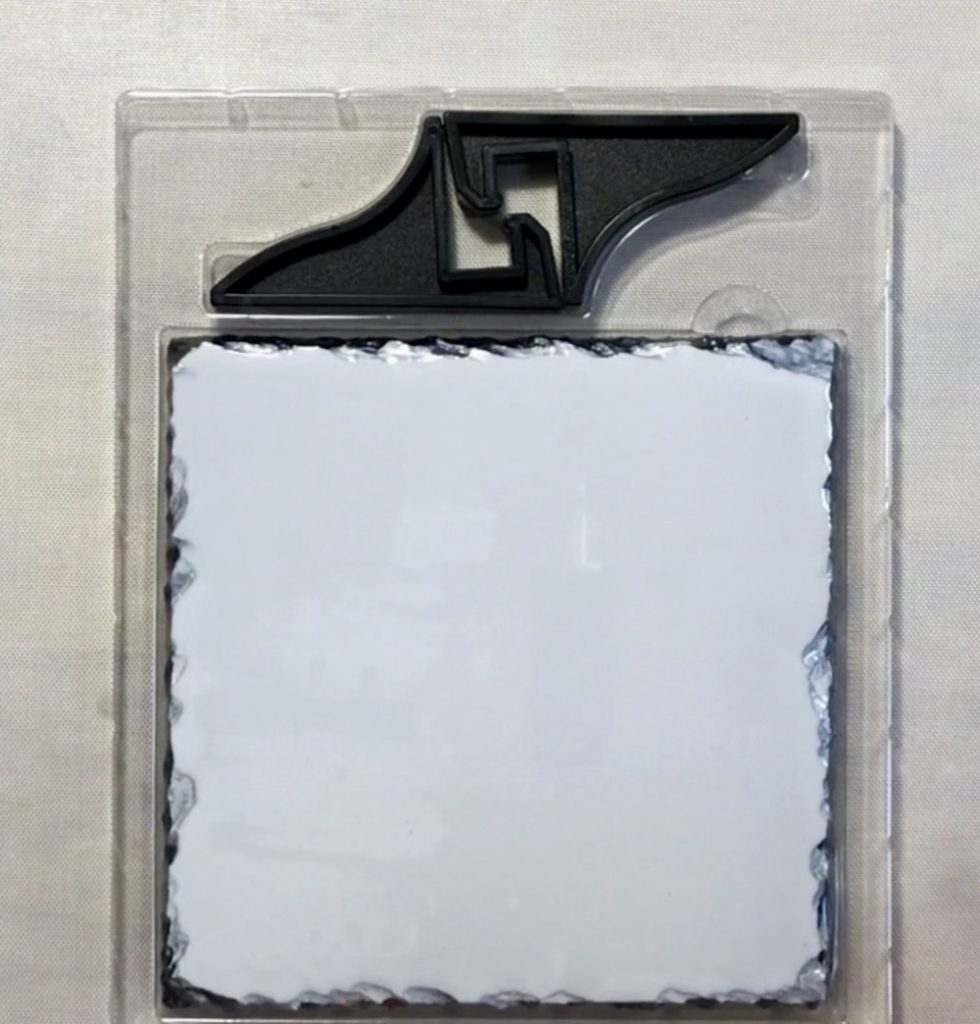 Photo of the Make Market Slate tile with the included display stand feet.