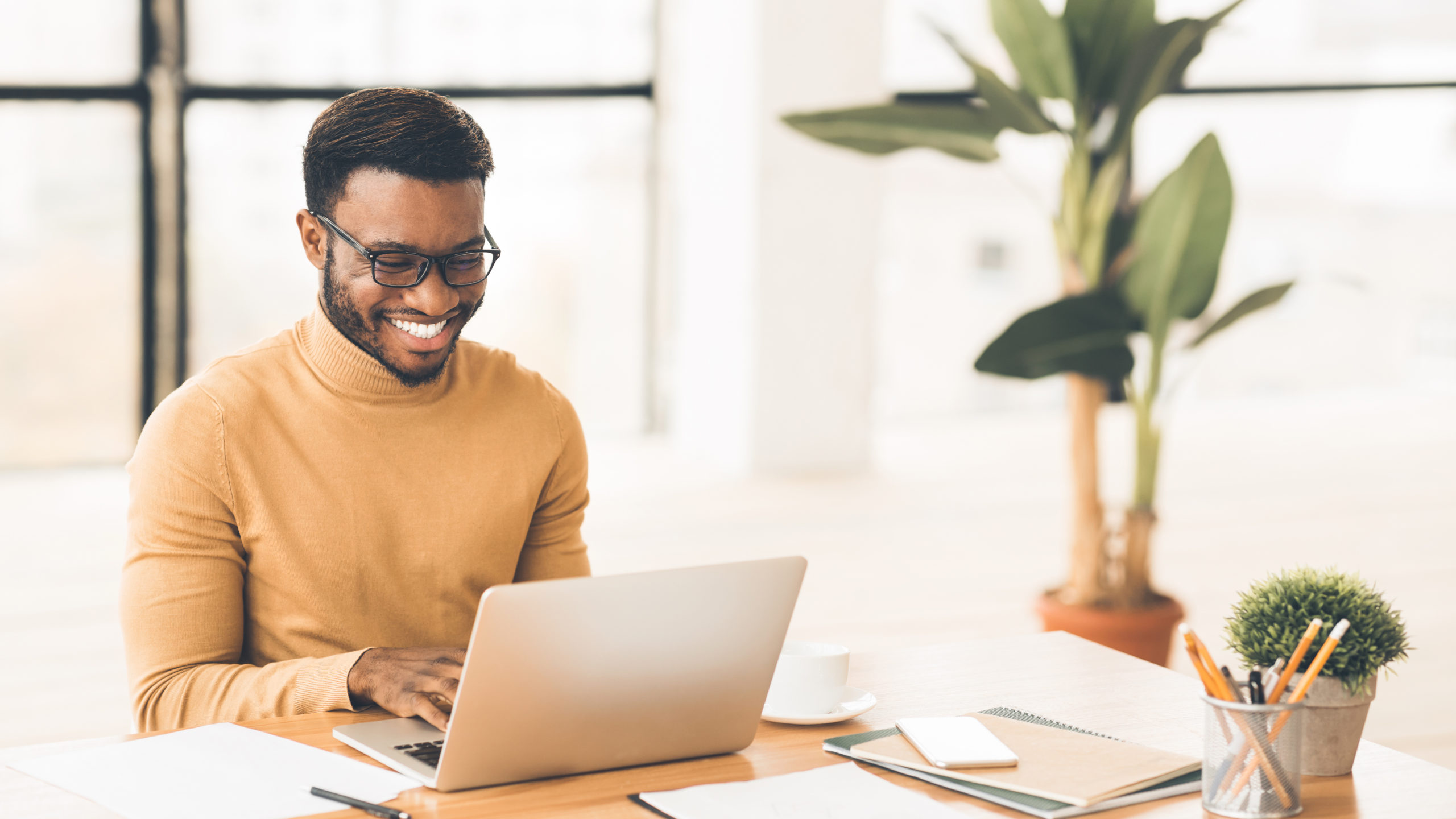 Headshot of handsome black guy using laptop The Computer Guild