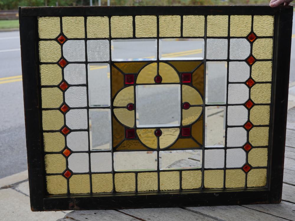 Antique stained glass window with jewels and bevels.