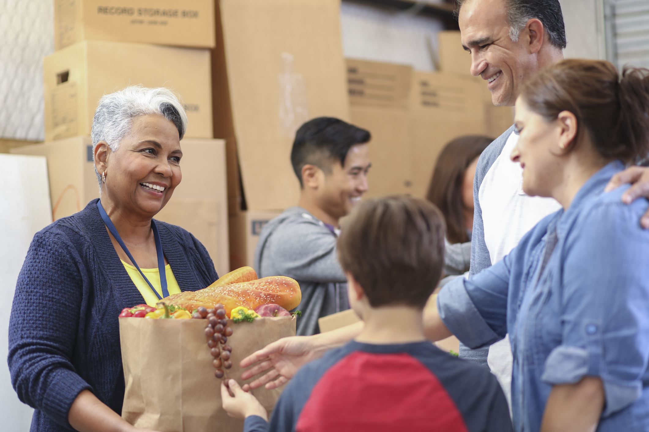 Multiethnic group of volunteers work at food bank. Corn Refiners