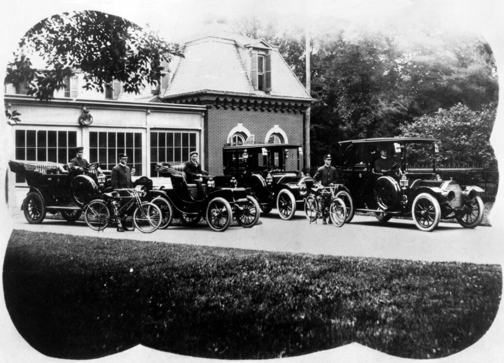 Official White House fleet with drivers and motorcycle police in 1909