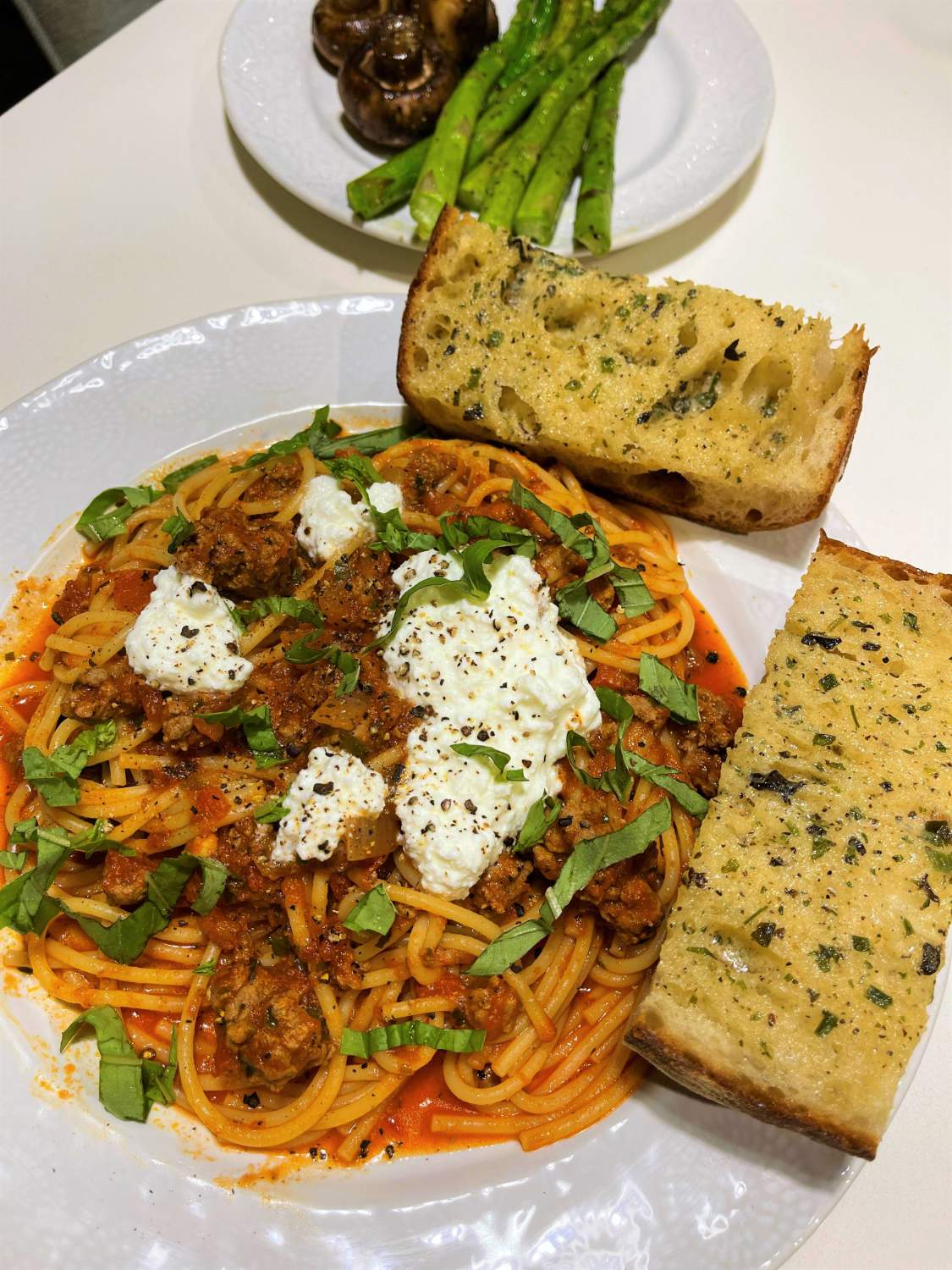 Solve Beefy spaghetti with dollops of ricotta, toasted garlic bread