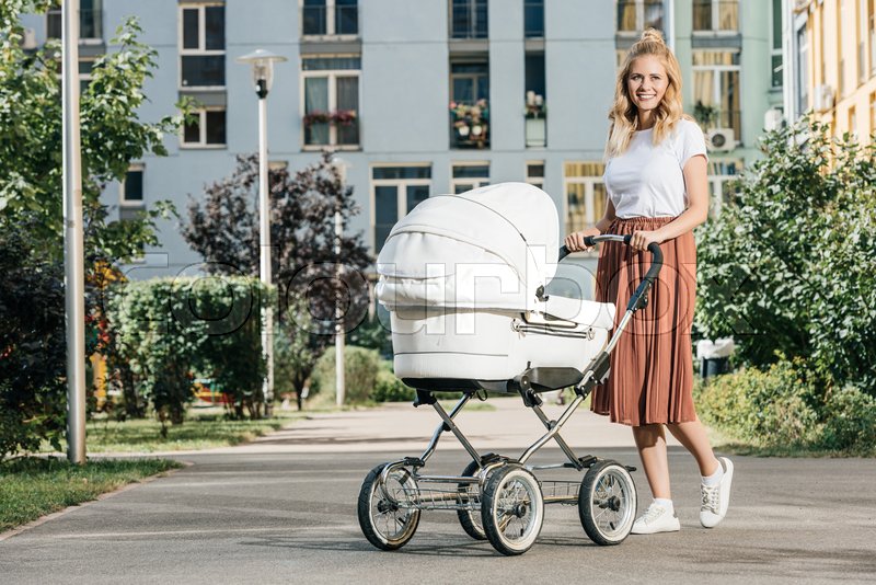 Mother walking with baby stroller on Stock image Colourbox